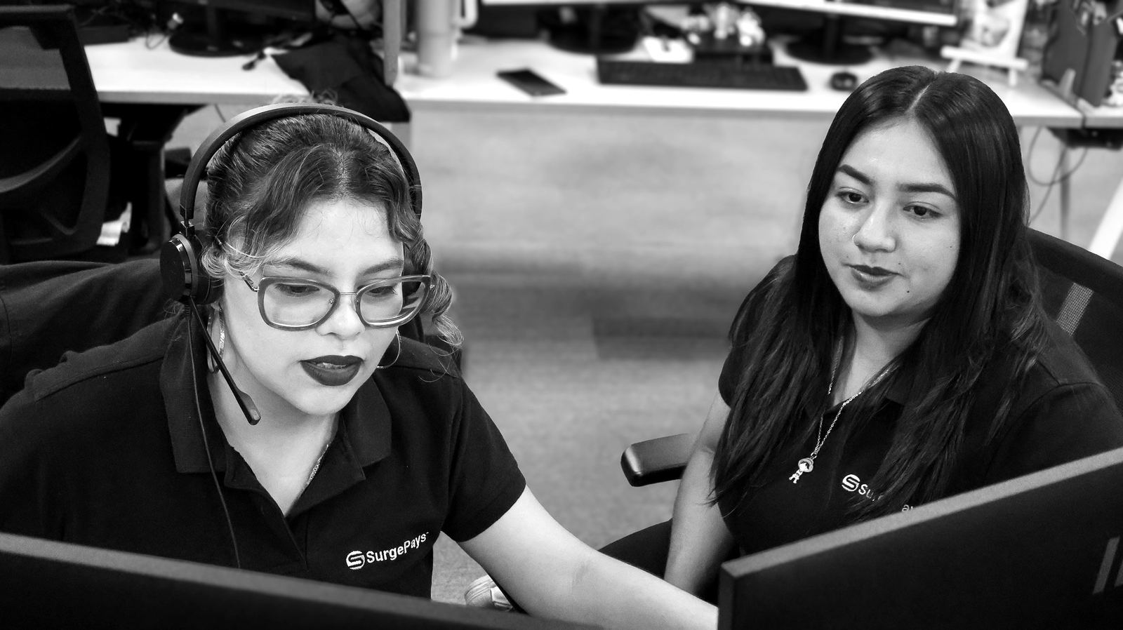 Two operations center agents working together at a screen